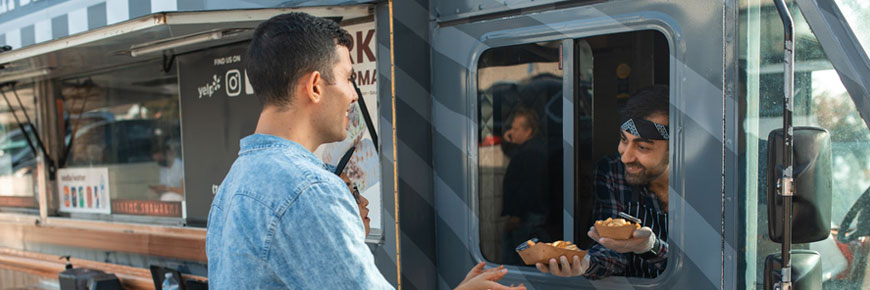 Food truck and man serving food to another man