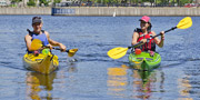 A man and a woman in a kayak on the waters of the Lachine Canal