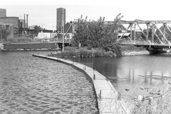 Black and white photo qui a view on the canal and a metal bridge