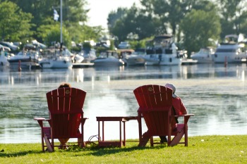 Two persons on red chairs looking at the canal 