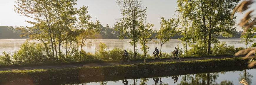 Cyclists riding along the Chambly Canal on the multipurpose path.