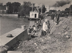 Seventeen workmen rebuilding a dock in the Chambly Canal in Saint-Jean-sur-Richelieu.