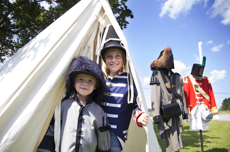Enfants visiteurs en costume d’époque dans une tente de la reconstitution de la bataille de 1812, Lieu historique national de la Bataille-de-la-Châteauguay