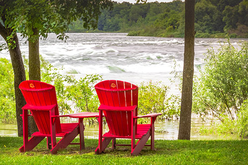 Deux chaises rouges devant le rapide de Coteau-du-Lac