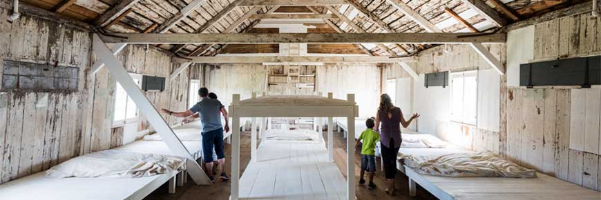 A family looks at the old beds in the lazaret building.