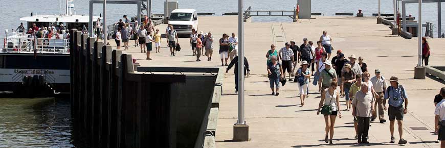 Visitors walking down the pier after arriving at Grosse-Île