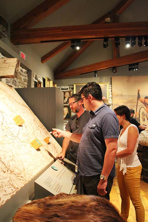 Visitors studying an electronical map describing the voyageurs continental expeditions