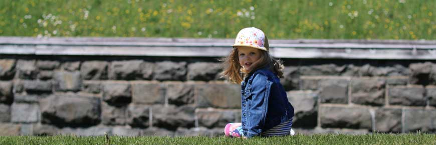 Enfant assis devant les murs de fortification.
