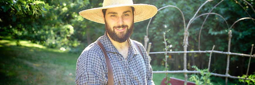 A young garderner smiling under his summer straw hat
