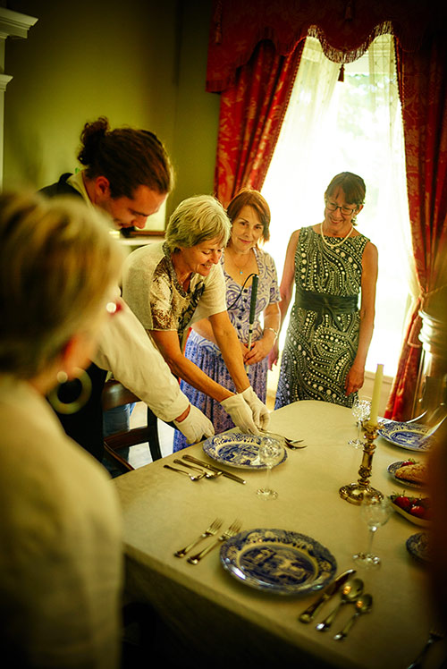 An adult group visiting Manoir Papineau around a table