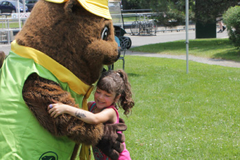A beaver mascot and a smiling little girl