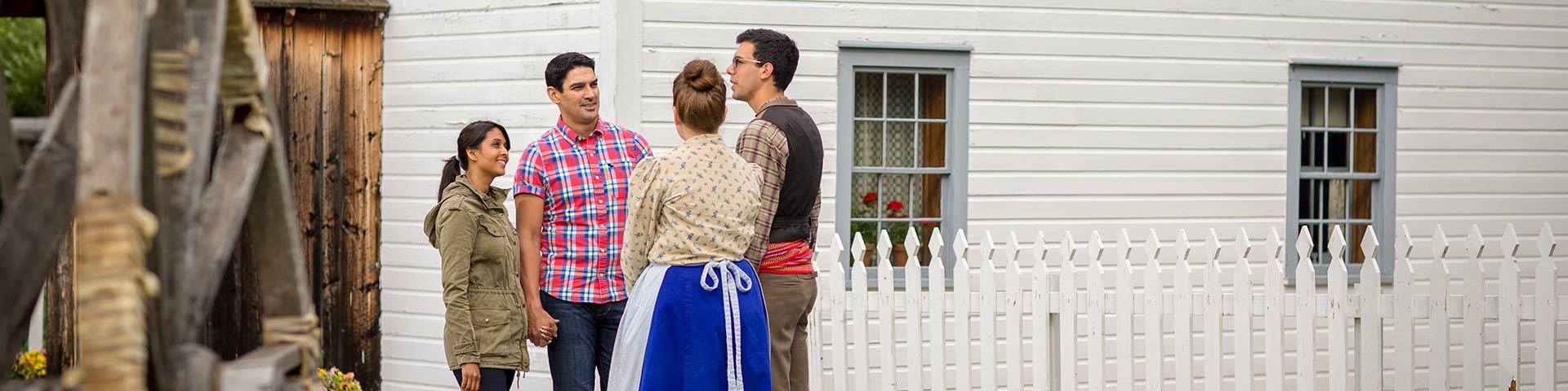 A couple interacts with a pair of costumed interpreters in front the Rectory at Batoche National Historic Site