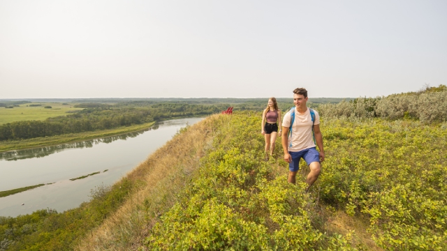 Two visitors walking on Li pchi shmayn trail overlooking the South Saskatchewan River.
