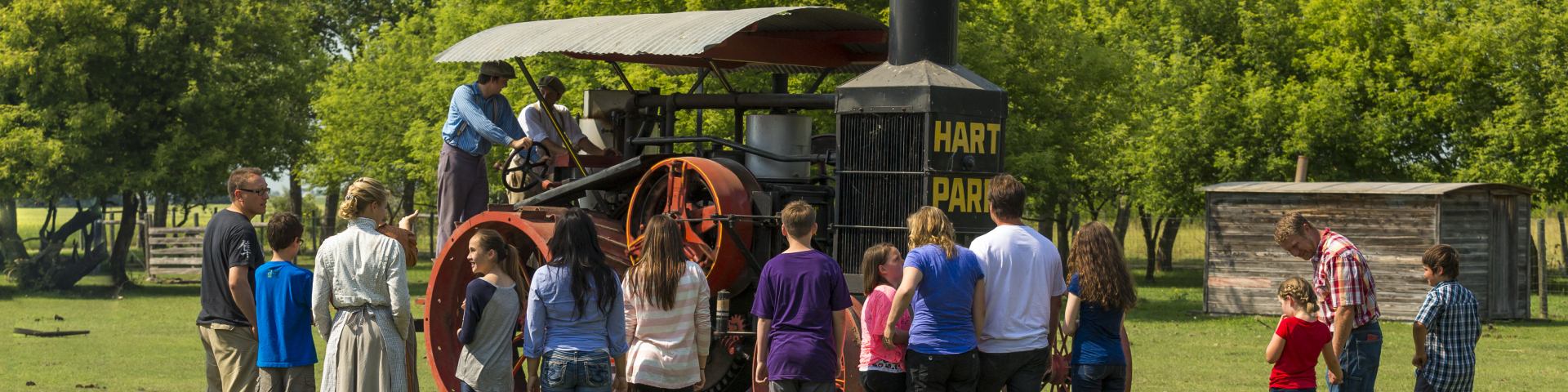 Visiteurs assistant à une démonstration du fonctionnement du tracteur Hart-Parr par des interprètes en costume d'époque au lieu historique national du Homestead-Motherwell 