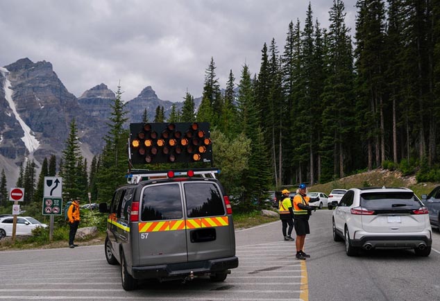 A person directing traffic along a mountain highway.