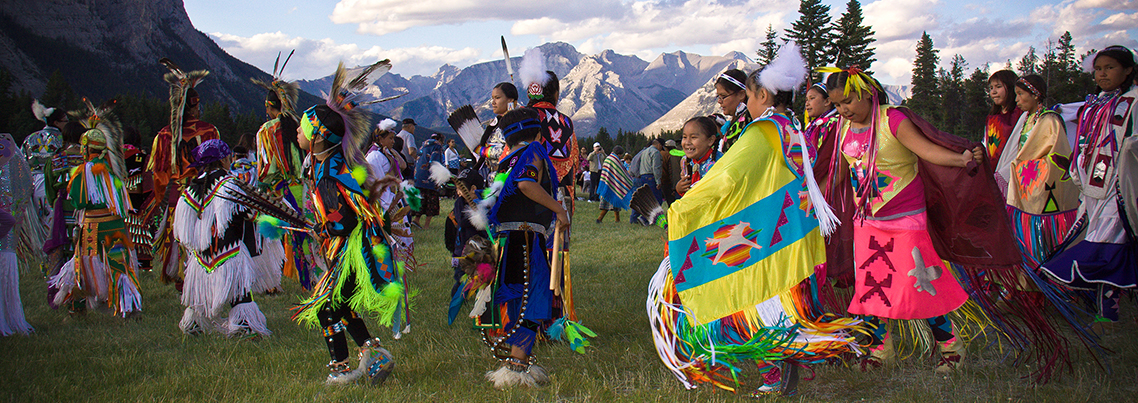 Indigenous People dancing in a meadow in the mountains