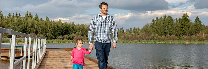 A father and daughter walk along the living Waters Boardwalk.