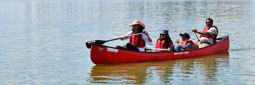 Une famille portant des gilets de sauvetage en canot sur le lac Astotin.