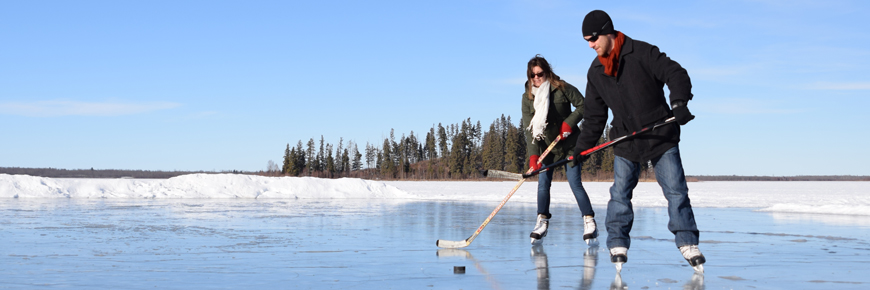 A couple plays hockey on the Astotin Lake skating rink. 