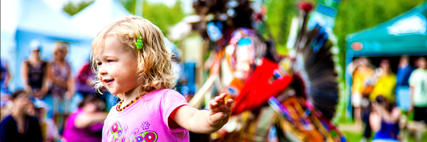Une petite fille accompagne des danseurs autochtones à l’occasion du Festival du bison au parc national Elk Island