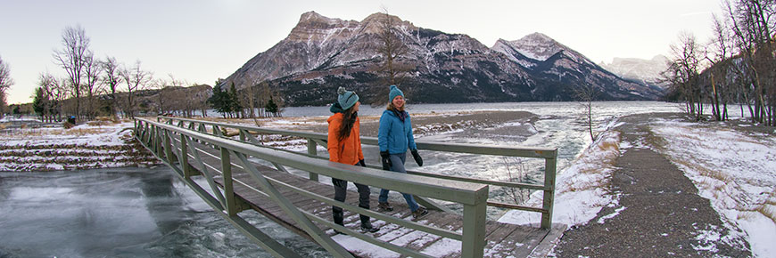 Two young adults enjoy a winter walk in Waterton townsite