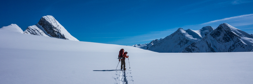 A backcountry skier breaking trail on a glacier