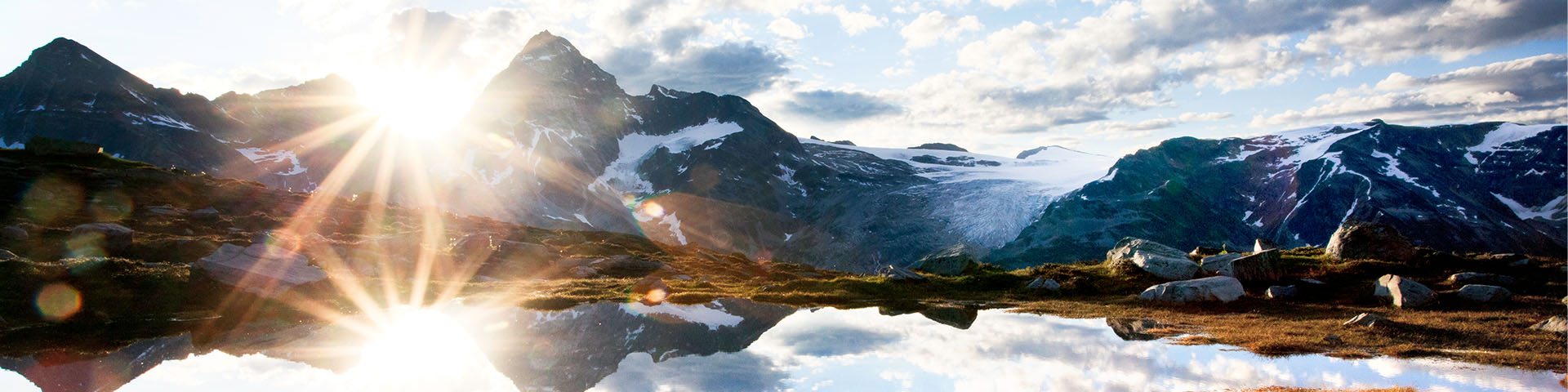 Sunrise at an alpine lake with a mountainous and glacial backdrop