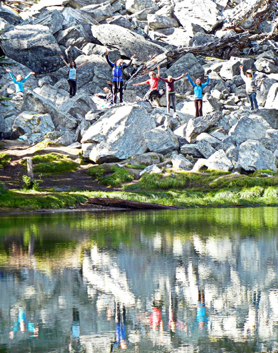 Des étudiants se tiennent sur une roche près d’un lac