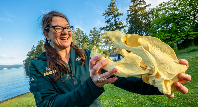 Parks Canada interpreter is presenting an interpretive program and is holding the replica of an animal skull