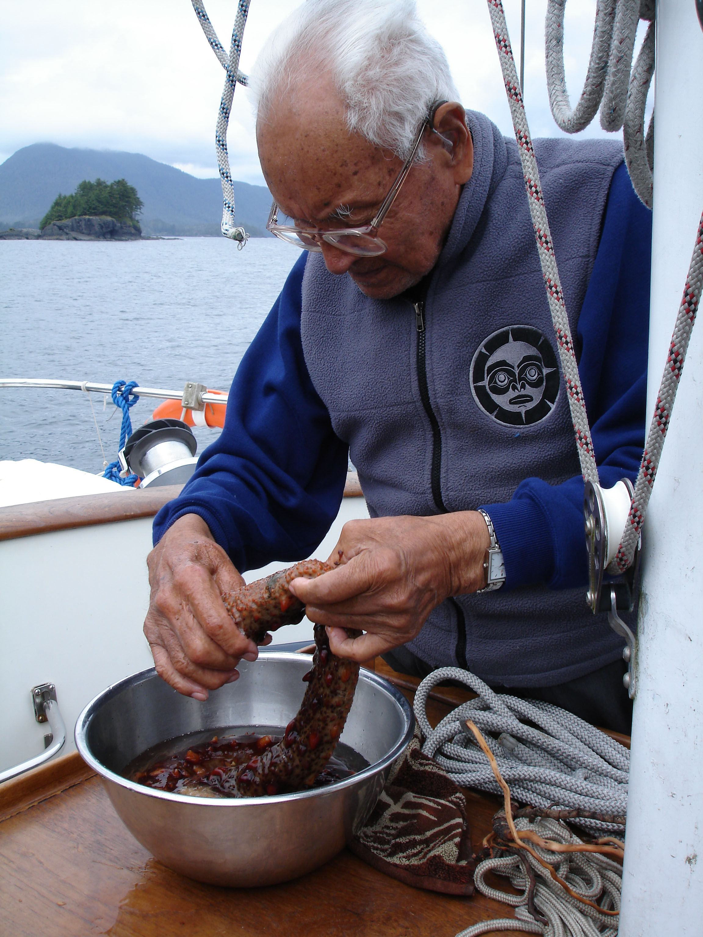 Haida elder prepares octopus on sailboat