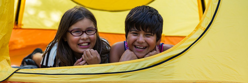 Two girls inside a yellow tent