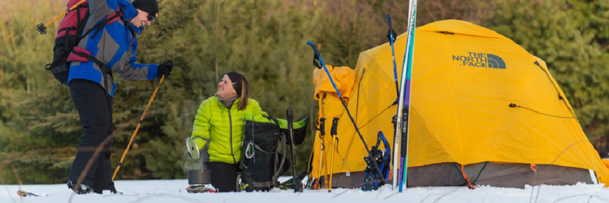 A couple near their tent in the snow