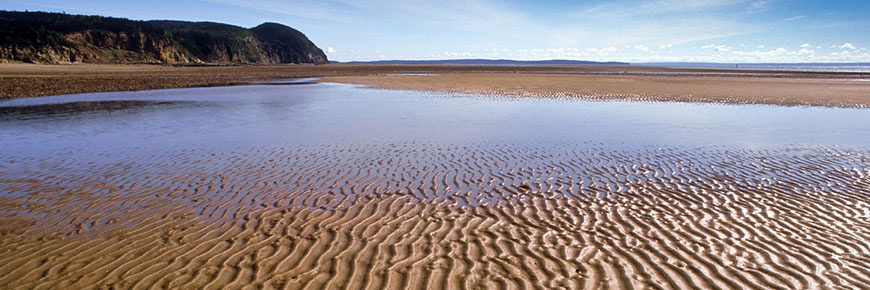 Plage à marée basse avec le sable ondulé.