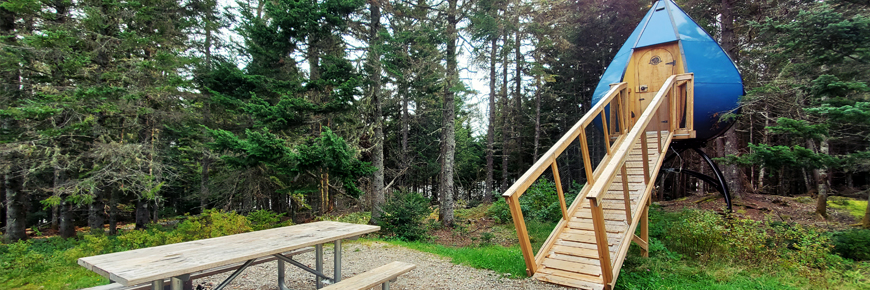 A camping accommodation shaped like a water dropplet, with a picnic table