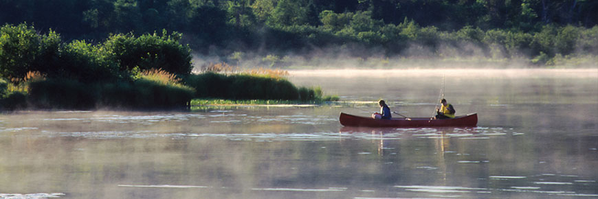 Two friends on a canoe fishing on the lake