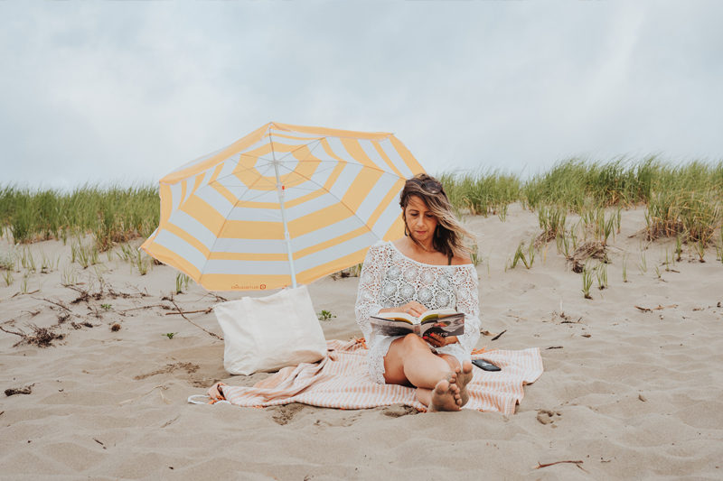 A woman reads a book on the beach