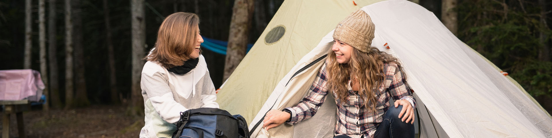 Two visitors talking near their tent.