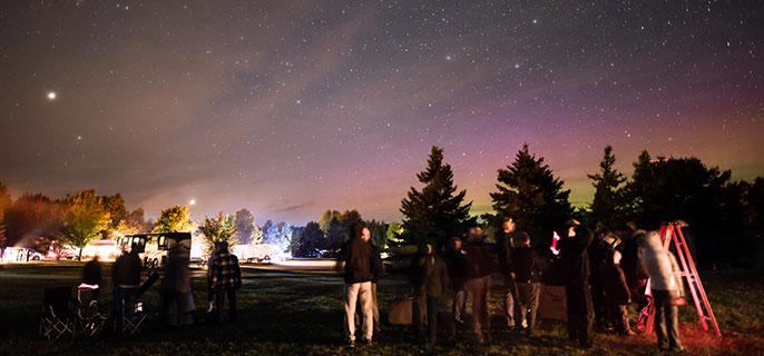 Un groupe de visiteurs observent le ciel étoilé