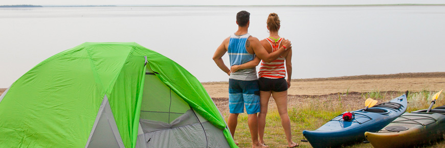 Un couple qui profite de la vue de la lagune à côté de leur tente