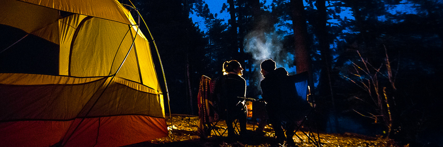 Un couple à leur emplacement de camping près du feu