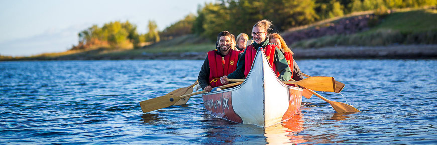 A group of visitors on a voyageur canoe