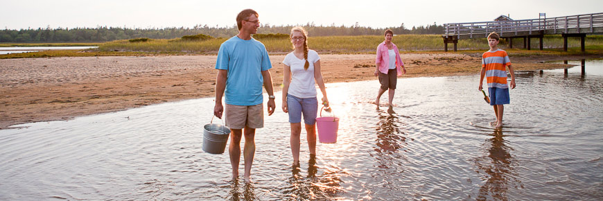 Une famille marchant dans l'eau avec des sceaux