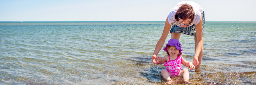 A women and her young daughter taking a dip in the ocean
