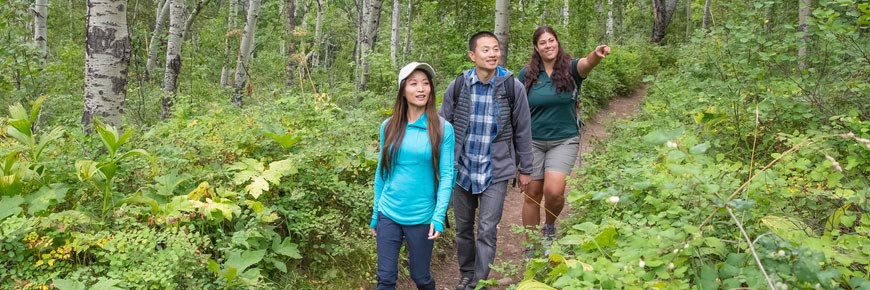 Des visiteurs sur un sentier de randonnée suivis d'un guide de Parcs Canada