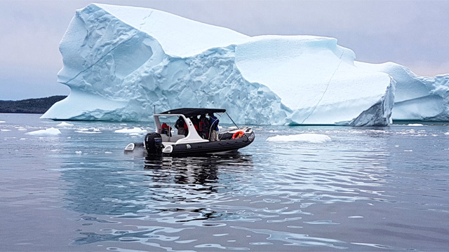 a tour boat next to an iceberg