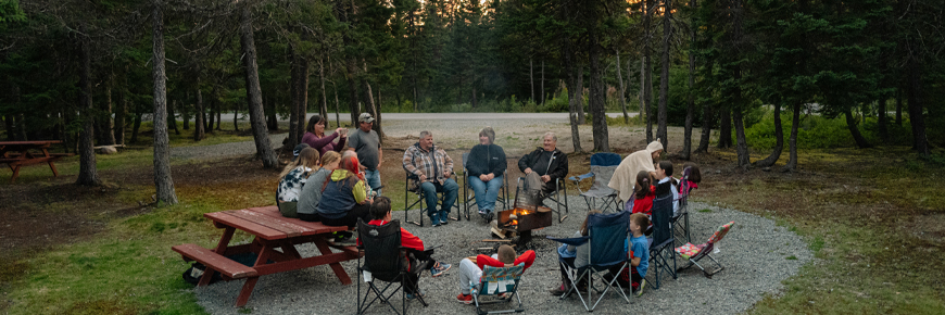 un groupe de personnes assises autour d'un feu de camp