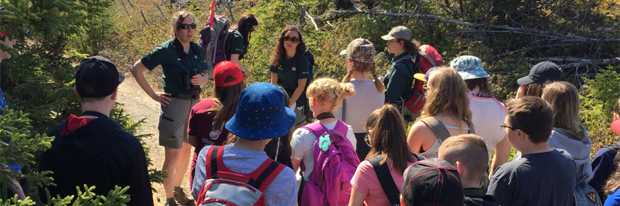 A Parks Canada employee leading a guided hike to a group of school children
