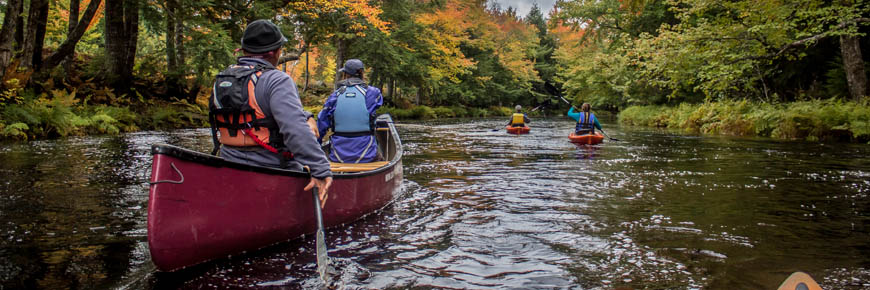 Deux kayaks et un canot à l'automne.