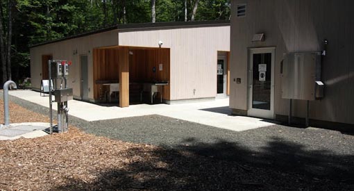 Two buildings: barrier-free washroom with a view of the outdoor dish-washing station on the left, and picnic shelter on the right.