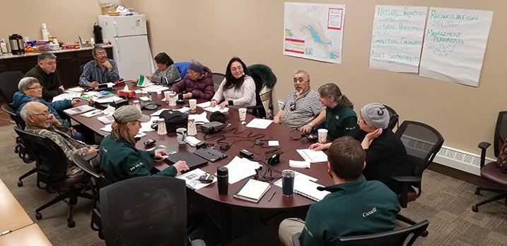 Members of the community and Parks staff discuss around a table in a conference room. 